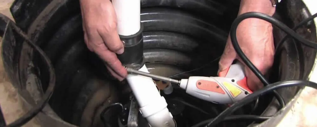 Sump pump installation technician connecting PVC discharge piping in Bradenton, FL